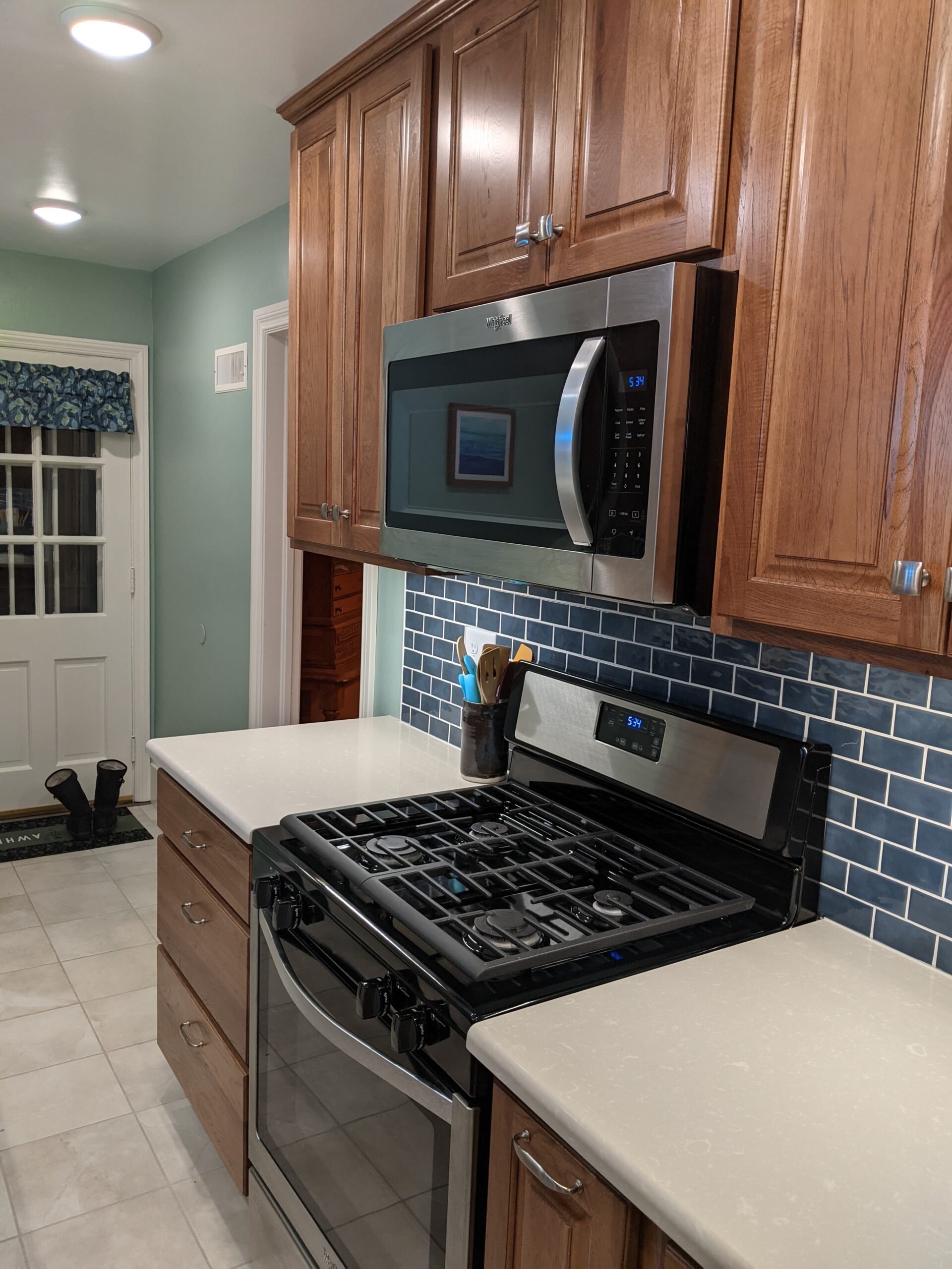 Shows the new stove area with the tiled backsplash and countertop space around the stove